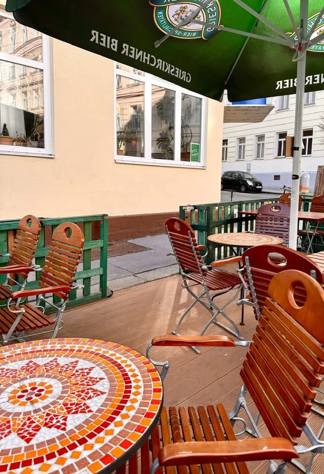 Außenbereich eines Cafés mit Tischen und Stühlen